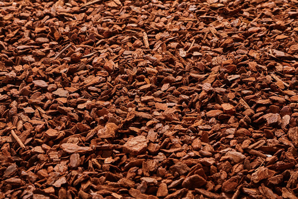 Natural full frame background on angled view of red and brown pieces of tree bark mulch for gardening or natural themes - Photo, image