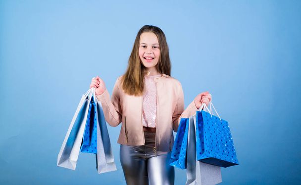 Happy child in shop with bags. Shopping day happiness. Buy clothes. Birthday girl shopping. Fashion boutique. Fashion trend. Fashion shop. Little girl with bunch packages. Fashion girl customer - Фото, зображення
