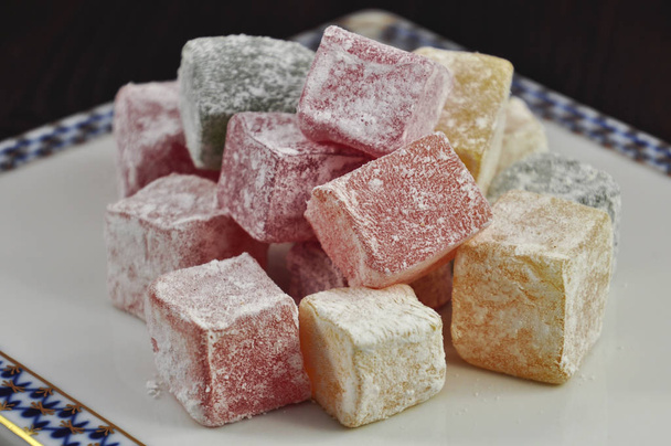 Square colorful Turkish sweets in powdered sugar - Фото, изображение
