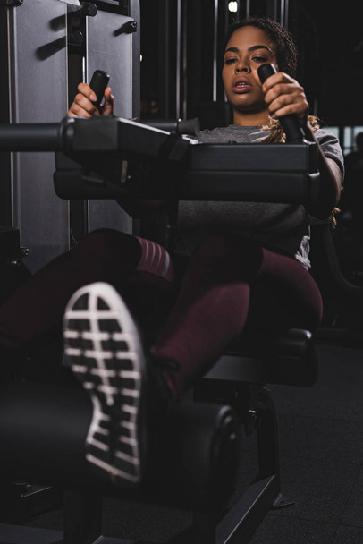 selective focus of african american girl working out on gym machine - Fotografie, Obrázek