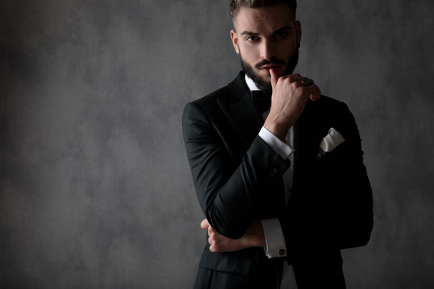 businessman standing with arms folded and touching lips seductiv - Photo, Image