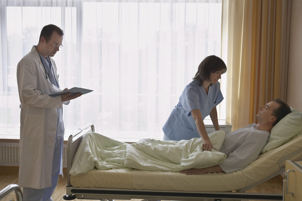 Nurse with doctor adjusting patient - Фото, изображение