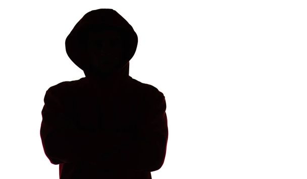 silueta masculina oscura en ropa deportiva casual con capucha, figura de un tipo que oculta su rostro, concepto de privacidad y confidencialidad
 - Foto, imagen