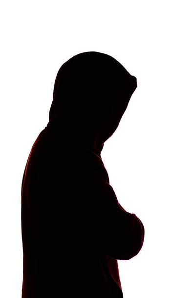 dark male silhouette in casual sportswear with a hood, figure of a guy hiding his face, concept of privacy and confidentiality - Foto, Bild