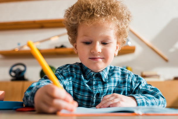 selective focus of smart kid writing in notebook  - Photo, Image