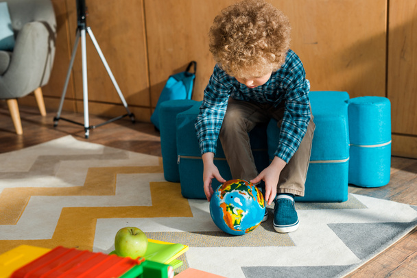 Smart-Kind hält Globus neben Spielzeugauto mit Apfel  - Foto, Bild