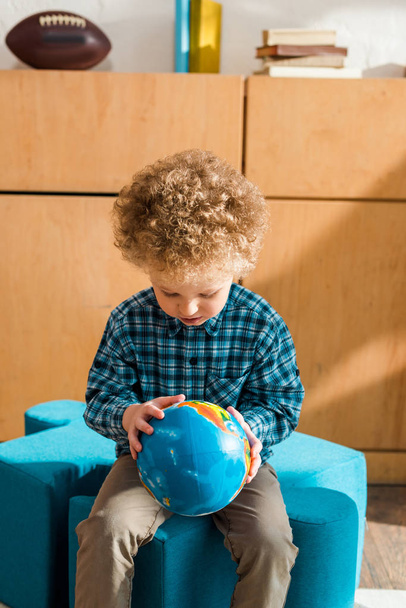 умный ребенок смотрит на земной шар дома
 - Фото, изображение