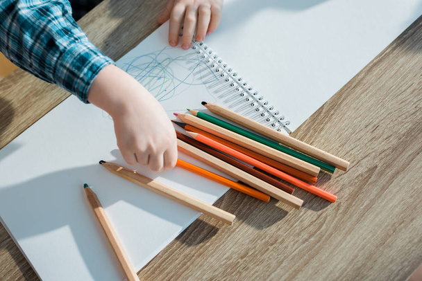 Turuncu kalem alan çocuğun üst görüntüsü  - Fotoğraf, Görsel
