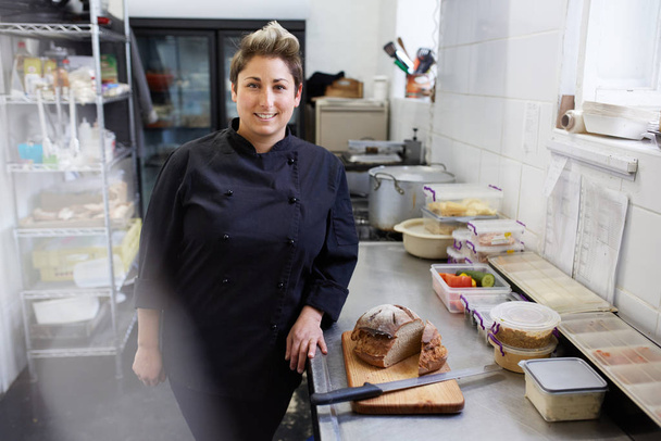 A female chef standing next to sliced bread - Фото, зображення