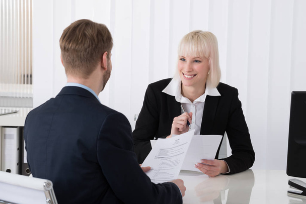 Young Businesswoman Discussing Over Resume With Male Candidate In Office - Foto, Imagem