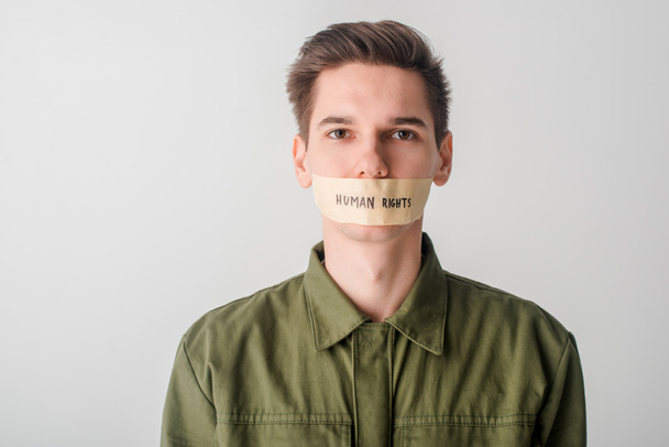 muž se skotskou páskou na ústech s lidskými právy písmo izolované na bílém - Fotografie, Obrázek