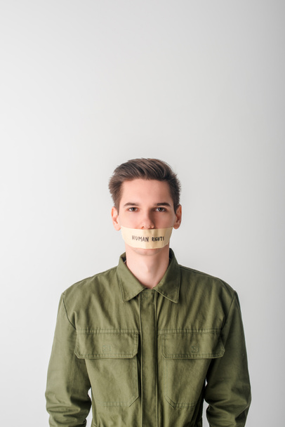 helpless man with scotch tape on mouth with human rights lettering isolated on white - Photo, Image
