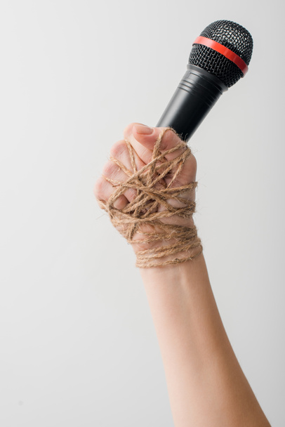 cropped view of woman with rope on hand holding microphone isolated on white, freedom of speech concept  - Photo, Image