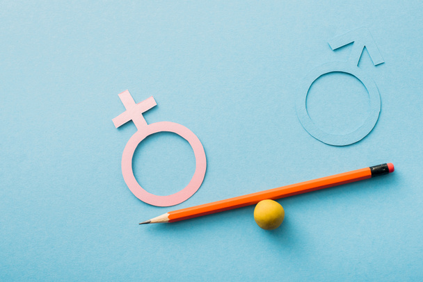 small ball and pencil with different genders isolated on blue, sexual equality concept  - Photo, Image