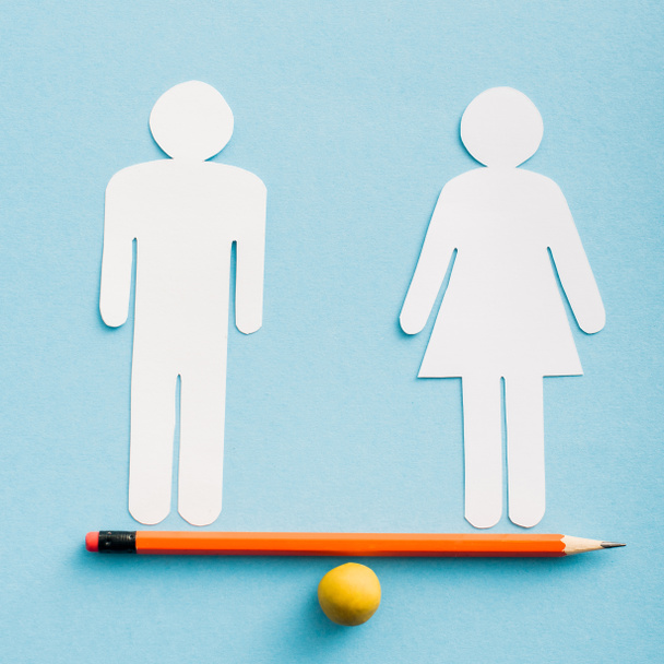 paper cut figures of couple as gender equality on pencil with small ball isolated on blue, sexual equality concept  - Foto, Imagem