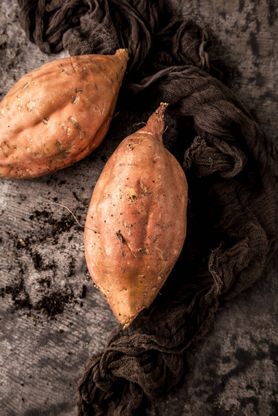 close-up view of tasty healthy whole sweet potatoes on grey surface - Foto, Imagem