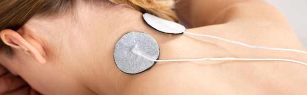Panoramic shot of stimulation electrodes on female neck isolated on grey - Foto, immagini