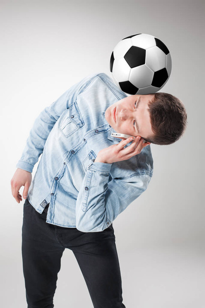 A portrait of a fan with ball, holding a phone on white background - Foto, imagen