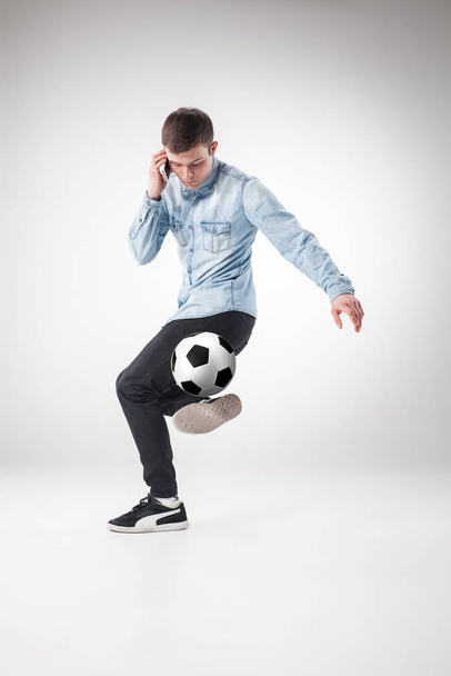 A portrait of a fan with ball, holding a phone on white background - Фото, зображення