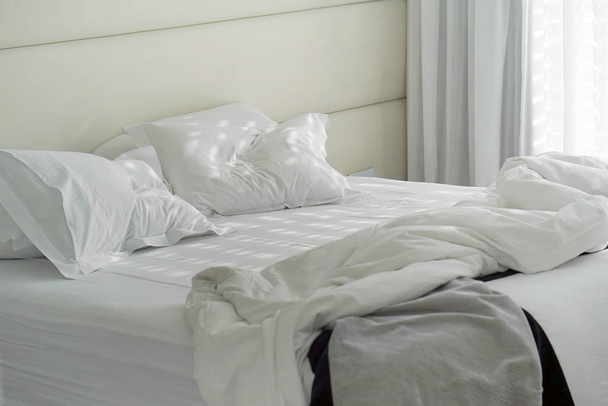 Hotel bed after use. Dirty bed pillow blanket room. - Photo, Image
