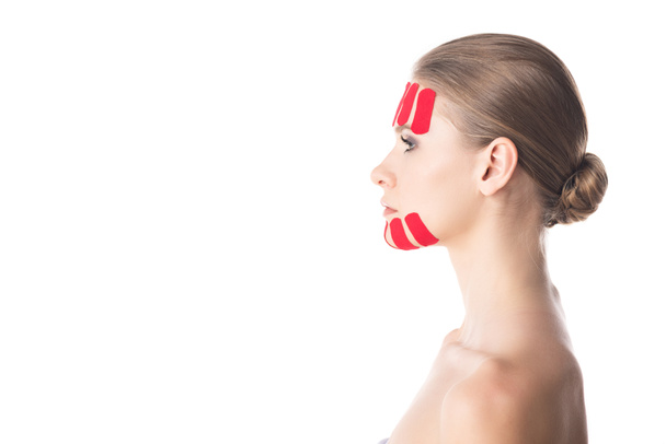 Side view of kinesiology tapes on chin and forehead of beautiful girl isolated on white  - Foto, Bild