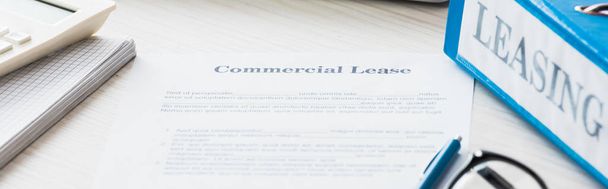 panoramic shot of folder near document with commercial lease lettering on desk  - Photo, Image