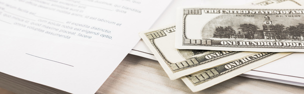 панорамный снимок долларовых купюр рядом с документами и ручкой на столе
  - Фото, изображение