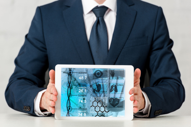 recortado vista de hombre de negocios en traje celebración tableta digital con aplicación médica en blanco
  - Foto, Imagen