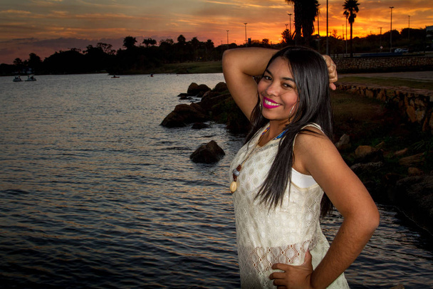 Υπέροχη νεαρή Βραζιλιάνα γυναίκα σε ένα πάρκο με τη λίμνη στο βάθος - Φωτογραφία, εικόνα