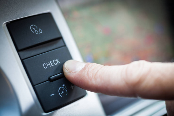 doigt appuyant sur le bouton de vérification à l'intérieur d'une voiture
. - Photo, image