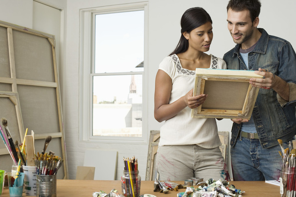 Multiethnic couple looking at canvases - Photo, Image