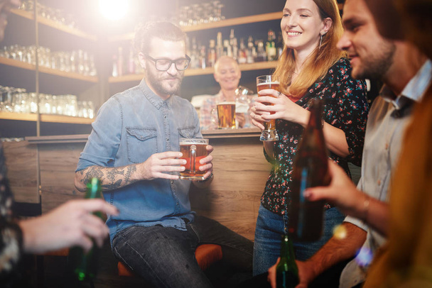 Groupe d'amis boire de la bière, bavarder et passer du bon temps au pub. Sortie nocturne
. - Photo, image