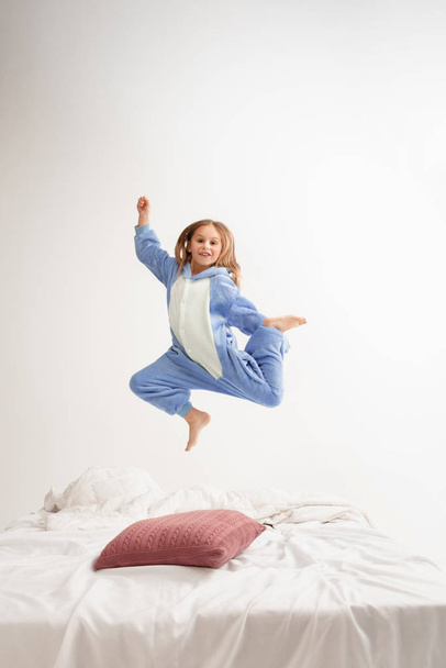 Little girl in soft warm pajama having party colored bright playing at home - Фото, зображення