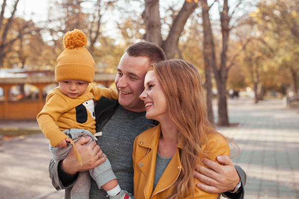 Beautiful happy family on a walk in the autumn park - 写真・画像
