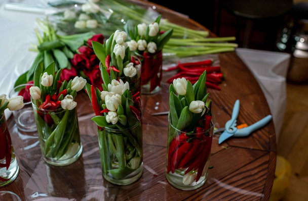 горизонтальна фотографія столу з безліччю квіткових композицій
 - Фото, зображення