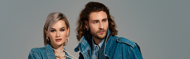 panoramic shot of stylish man and woman in denim jackets isolated on grey - Fotó, kép