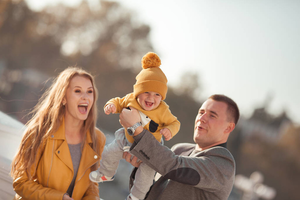 Mooie gelukkige familie op een wandeling in het herfstpark - Foto, afbeelding