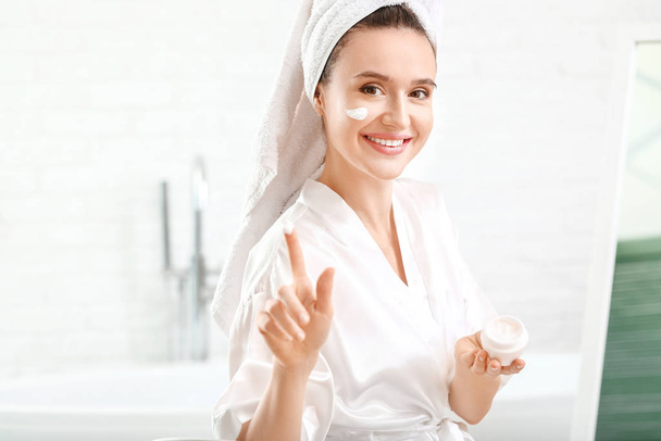 Beautiful young woman applying cream at home - Foto, Imagem