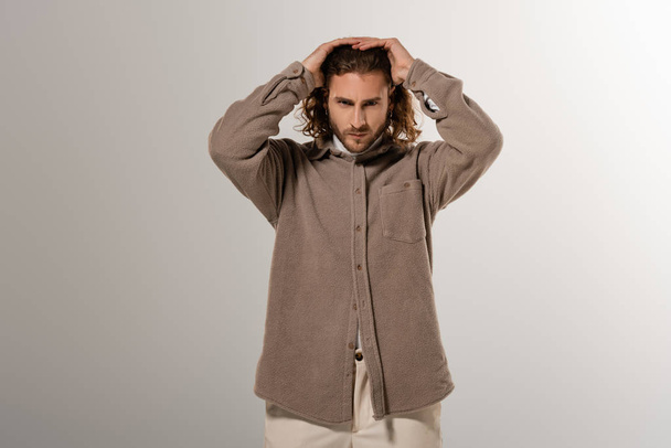 handsome man in shirt touching head on grey background  - Fotografie, Obrázek