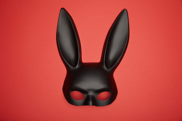 top view of black rabbit mask isolated on red - Fotoğraf, Görsel