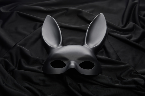 Siyah tekstil arka planında tavşan maskesi - Fotoğraf, Görsel