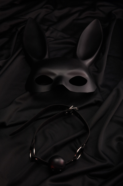 nyúl maszk és gag fekete textil háttér - Fotó, kép