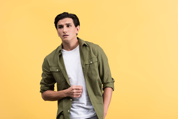 worried man in casual clothes, isolated on yellow - Photo, Image