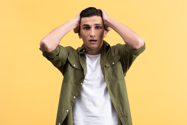 portrait of worried young man, isolated on yellow - Foto, immagini