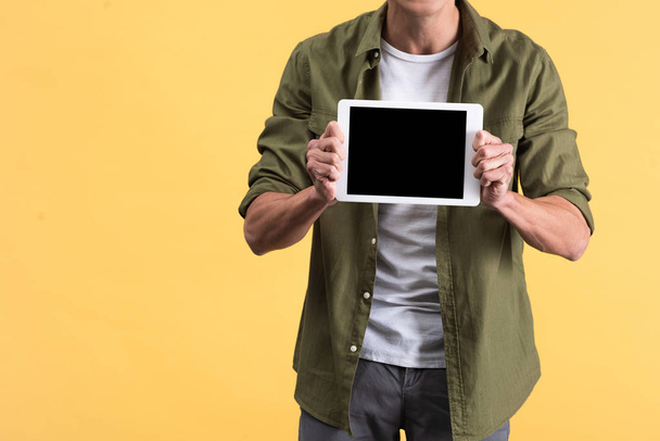 cropped view of man showing digital tablet with blank screen, isolated on yellow - Photo, Image
