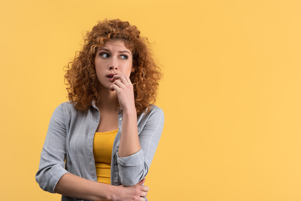 portrait of pensive redhead young woman, isolated on yellow - Φωτογραφία, εικόνα