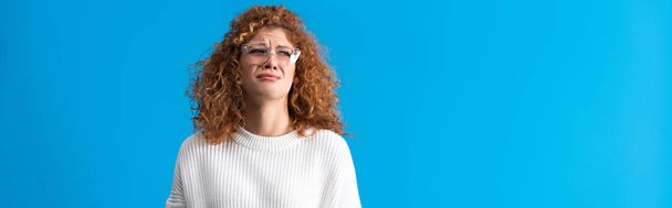 panoramic shot of beautiful redhead upset girl crying isolated on blue - Fotoğraf, Görsel