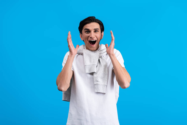 portrait of excited young man, isolated on blue - Foto, afbeelding