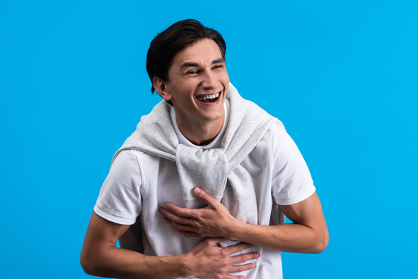 portrait of laughing young man, isolated on blue - Valokuva, kuva
