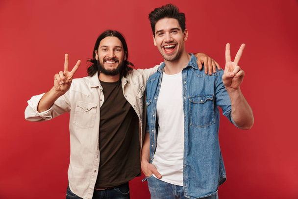 Photo of young happy guys smiling and gesturing peace sign - Foto, Bild